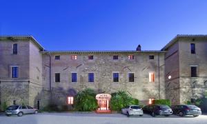 een groot stenen gebouw met auto's geparkeerd voor het bij Lo Spedalicchio in Bastia Umbra
