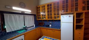 プエルトイグアスにあるPosada de Anaのキッチン(木製キャビネット、白い冷蔵庫付)