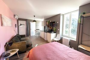 um quarto com uma cama e uma sala de estar em KASA LOUNGE em Rive-de-Gier