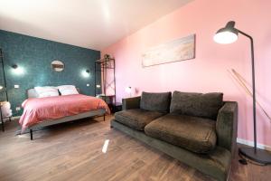 um quarto com uma cama e um sofá em KASA LOUNGE em Rive-de-Gier