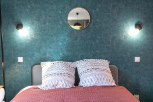 um quarto com uma cama com duas almofadas e um espelho em KASA LOUNGE em Rive-de-Gier