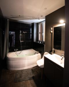 uma grande casa de banho com banheira e lavatório em KASA LOUNGE em Rive-de-Gier