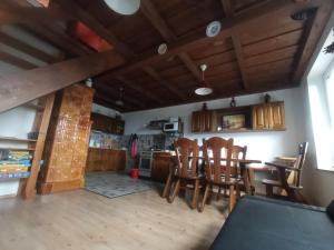 a kitchen and dining room with a table and chairs at Pele vendégház in Velem