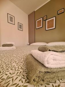 Un dormitorio con 2 camas y una pared con cuadros. en Casa Vacanza - La Maison Jolie - Settecamini, en Settecamini