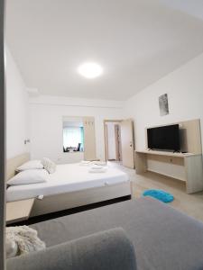 a white bedroom with a bed and a tv at Villa Bellevue in Novi Vinodolski