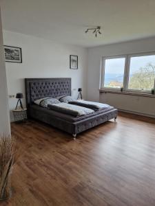 een grote slaapkamer met een groot bed op een houten vloer bij Landvilla Dagobert in Malsfeld