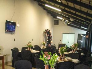 a conference room with tables and chairs with flowers at km eventos e Hospedagem in Uberaba