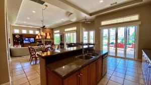 a kitchen with a sink and a living room at TEE TIME: 2 bed + convertible den; private pool and spa, VIEWS! A Greenday property. in Rancho Mirage