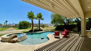 a swimming pool with a patio with two chairs at TEE TIME: 2 bed + convertible den; private pool and spa, VIEWS! A Greenday property. in Rancho Mirage