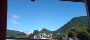 a view of a mountain from a window at Aracari Inn Mindo in Mindo