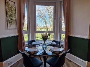 a dining room with a table and chairs and a large window at HIL Stays - Baxter Park View in Dundee