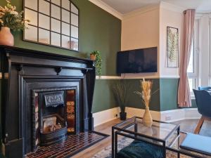 a living room with a fireplace and a tv at HIL Stays - Baxter Park View in Dundee