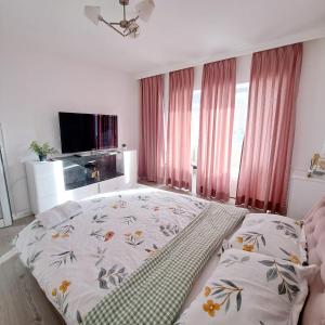 - une chambre avec un grand lit et une télévision dans l'établissement Apartament Elegant - Zona Alfa, à Arad