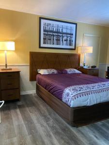 ein Schlafzimmer mit einem großen Bett und zwei Nachttischen in der Unterkunft Pine Ridge Motel in Timmins