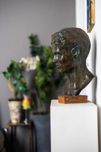 un busto de bronce de un hombre sentado sobre una mesa en Art Apartment Galliera en Bolonia