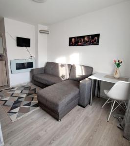 uma sala de estar com um sofá e uma mesa em Apartament Elegant - Zona Alfa em Arad