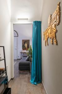 sala de estar con cortina azul y sofá en Art Apartment Galliera en Bolonia