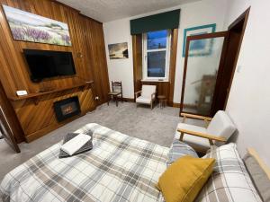 ein Hotelzimmer mit einem Bett und einem TV in der Unterkunft Glebe Street Dumfries in Dumfries