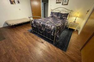 a bedroom with a bed and a lamp on a wooden floor at Creekside Dream Game Room Sleeps 12 bbq near town in Oakhurst