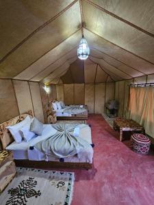 una camera con 2 letti in una tenda di Najma Luxury Camp a Merzouga