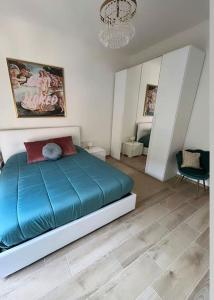 um quarto com uma cama azul e um lustre em Appartamento romantico centro storico con parcheggio comodo em Reggio Emilia