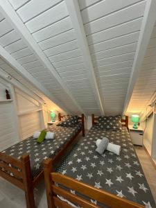 2 łóżka w pokoju z białym sufitem w obiekcie Maison bord de mer à 100 m w mieście Saint-François