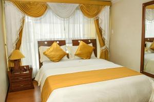 una camera da letto con un grande letto con cuscini gialli di Hotel Senegal a Pasto