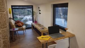 a room with a table with a laptop on it at Casa do Geraço - Douro Guest House in Várzea do Douro