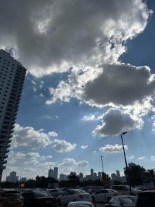 ein wolkiger Himmel mit Autos auf einem Parkplatz in der Unterkunft provis in Schardscha