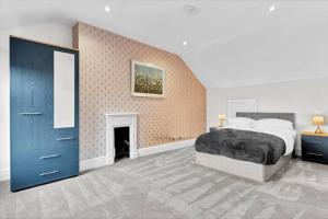 a bedroom with a large bed and a fireplace at Spacious House - Sleeps 10 - Central Location - Free Parking, Fast WiFi and Smart TV with Nerflix by Yoko Property in Northampton