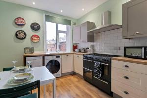 a kitchen with a stove and a dishwasher at Spacious House - Sleeps 10 - Central Location - Free Parking, Fast WiFi and Smart TV with Nerflix by Yoko Property in Northampton