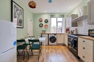 a kitchen with a table and chairs and a refrigerator at Spacious House - Sleeps 10 - Central Location - Free Parking, Fast WiFi and Smart TV with Nerflix by Yoko Property in Northampton