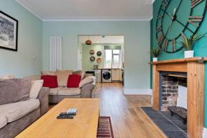 a living room with a couch and a fireplace at Spacious House - Sleeps 10 - Central Location - Free Parking, Fast WiFi and Smart TV with Nerflix by Yoko Property in Northampton