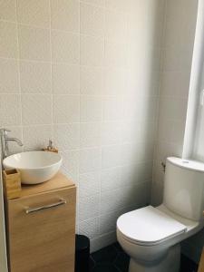 a bathroom with a white toilet and a sink at Charmette in Dijon