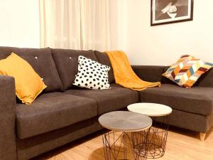 a living room with a couch with pillows and two tables at Pequeño Hogar (Garaje gratis) in Zamora