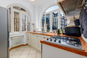 uma cozinha com fogão e algumas janelas em [near Funicolar] Bergamo Alta Design HOUSE 1 em Bérgamo