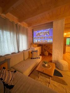 un soggiorno con divano e grande schermo di Panorama Sucha Góra a Skawica