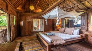 a bedroom with a bed with a canopy at Ratua Private Island Resort in Aimbuei Bay