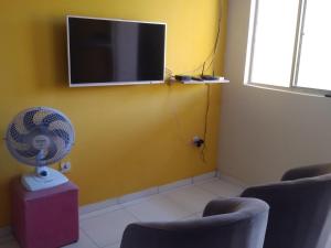 a room with a fan and a tv on a wall at Casa São Miguel dos Milagres in São Miguel dos Milagres