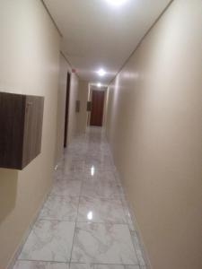 um longo corredor com piso em azulejo num edifício em Hotel atlântica em São Paulo