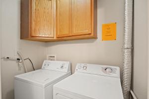 a laundry room with a washing machine and cabinets at Cozy 2-Bedroom Condo in Prime Siesta Key Location in Sarasota