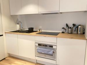 a kitchen with white cabinets and a stove top oven at Fomento by Wynwood House in Madrid