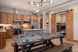 duża kuchnia z drewnianym stołem z niebieskimi miseczkami w obiekcie NEW Condo Grand Park W/Hot Tub & Mountain View w mieście Fraser
