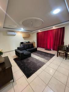een woonkamer met een bank en een rood gordijn bij Kolo's Mayfair private apartments in Dar es Salaam