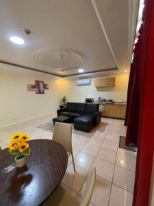 een woonkamer met een tafel en een bank bij Kolo's Mayfair private apartments in Dar es Salaam