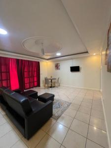 een woonkamer met een zwarte bank en een tafel bij Kolo's Mayfair private apartments in Dar es Salaam