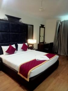 a bedroom with a large bed with red pillows at Hotel Luxury Holiday - Banjara hills prime location in Hyderabad