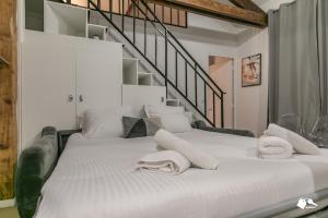 a large white bed with towels on top of it at MBA - Splendide Appart - Patay 3 - Proche Bercy in Paris