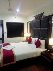 a bedroom with a large white bed with red pillows at Hotel Luxury Holiday - Banjara hills prime location in Hyderabad