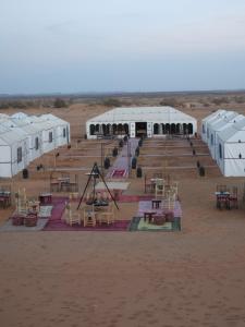 a row of tents in the middle of a desert at Najma Luxury Camp in Merzouga